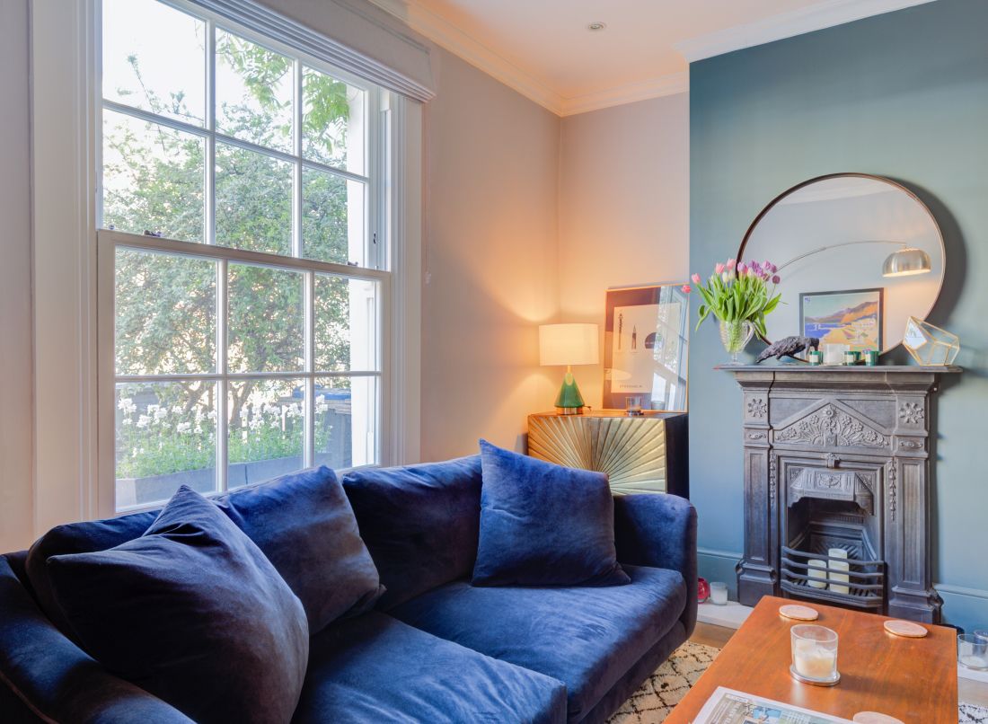 Heritage Sliding Sash Window behind a blue couch