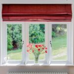a upvc sash windows with red blind and flowers on the window sill