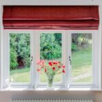 a upvc sash windows with red blind and flowers on the window sill