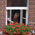 a woman washing white casement windows