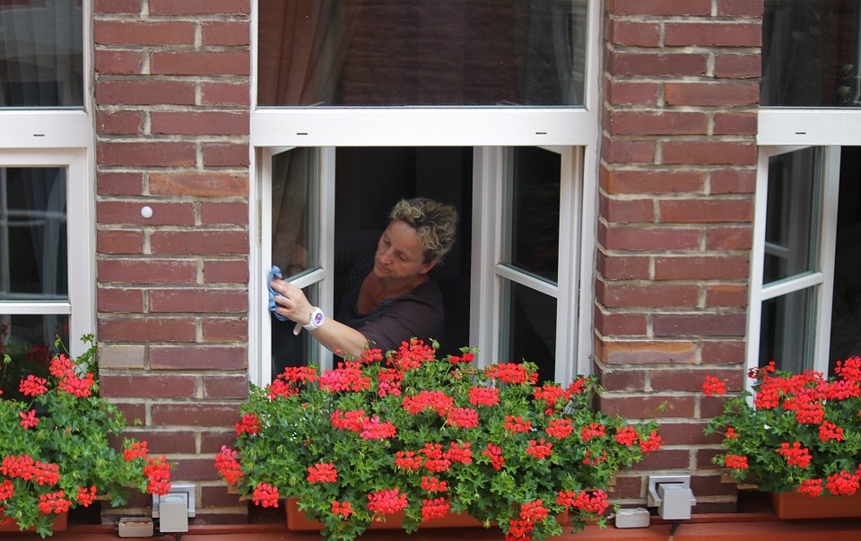 a woman washing white casement windows