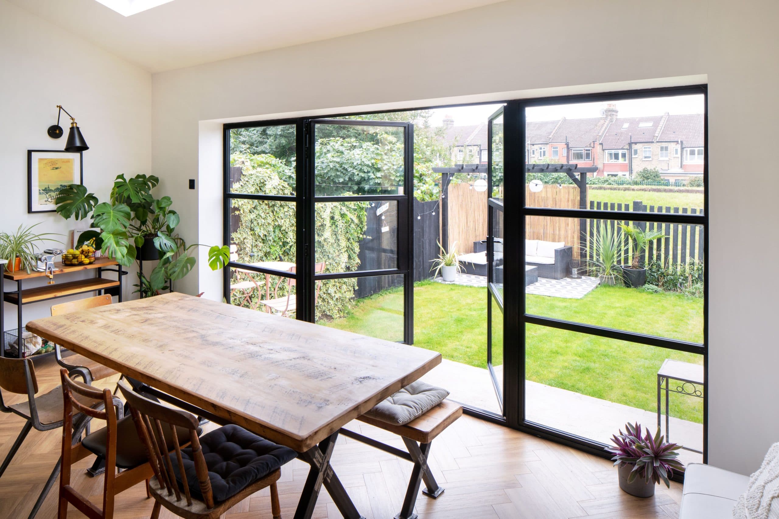 Room with black sash windows and open doors that leads to the garden