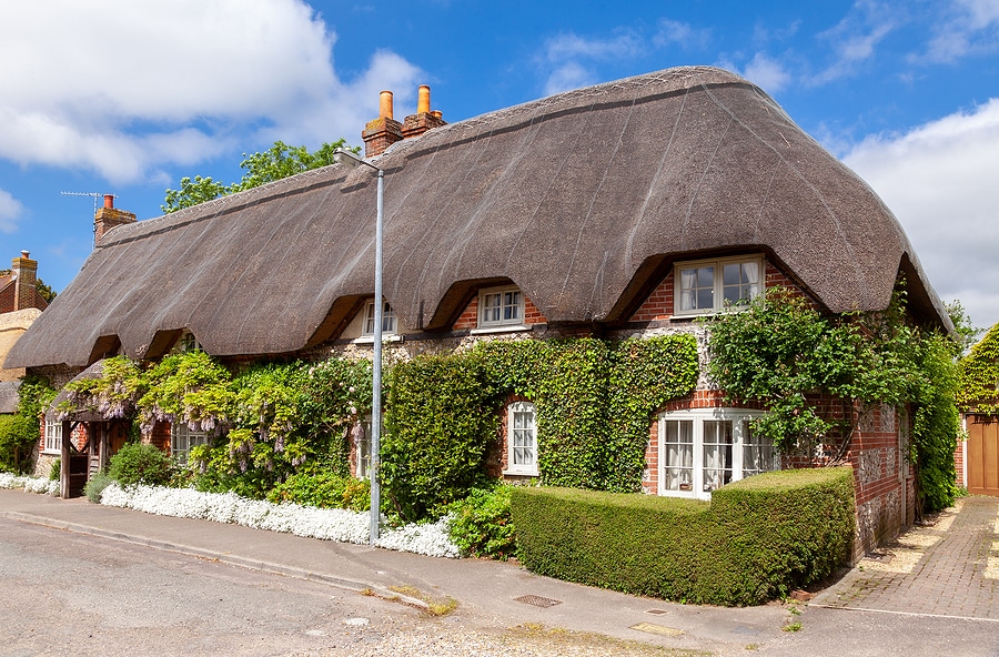 A street view of a traditional English country thatched cottage