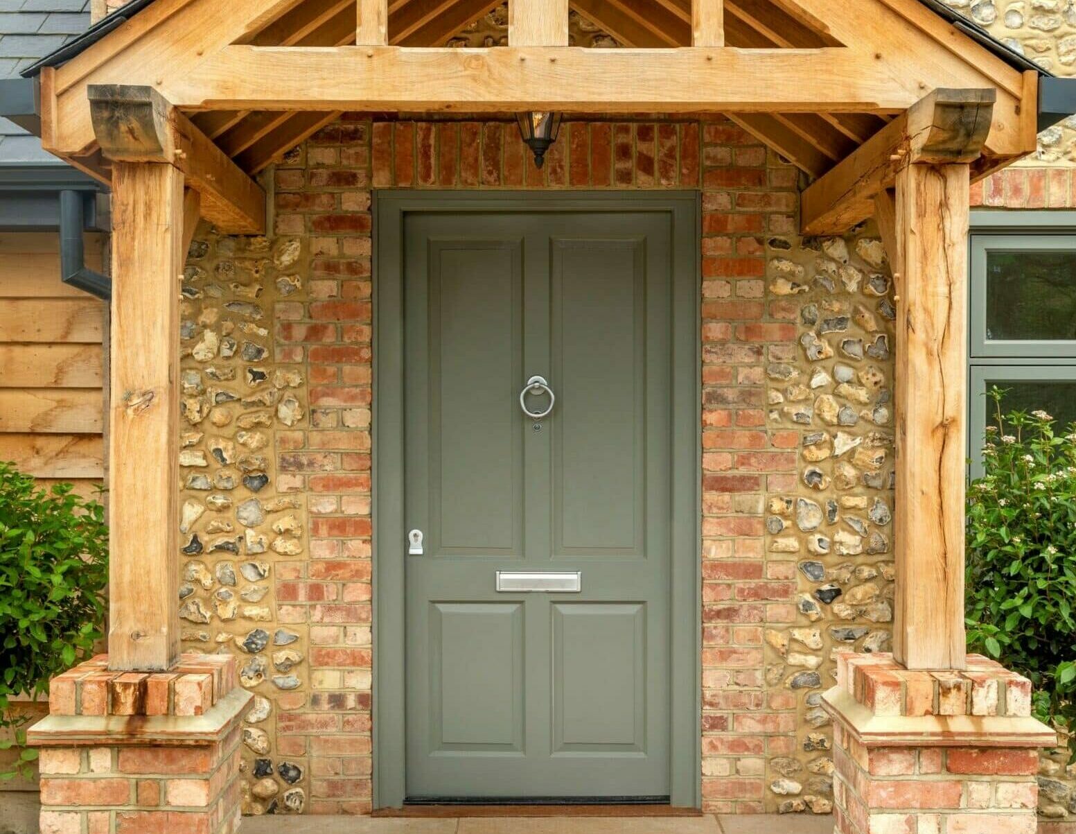 green front door under wooden porch
